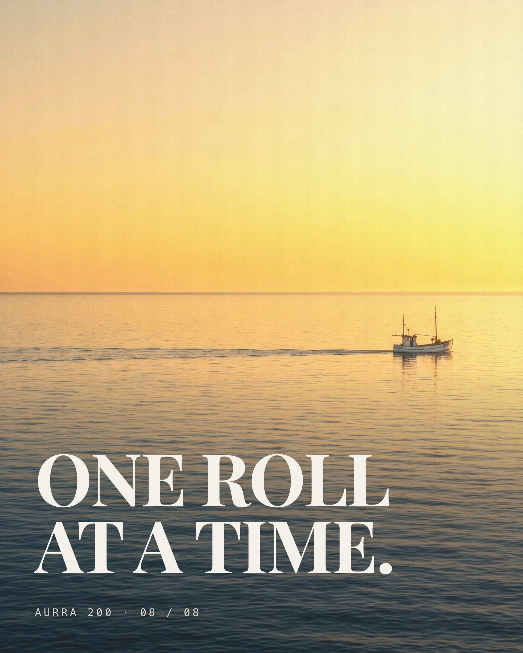 A photograph filling the slide, a small fishing boat crossing flat water at sunset under a sky that runs from orange to yellow. ONE ROLL AT A TIME. is set over the lower half in paper white serif capitals, with a faint ink gradient behind the letters so they stay readable on the water. AURRA 200 · 08 / 08 sits at the foot.